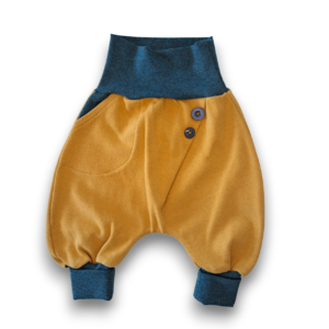 Gelbe Babyhose mit blauen Bündchen, Tasche und Knopfdekor, flach liegend auf weißem Hintergrund.