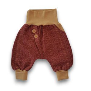 Babyhose aus weinrotem Stoff mit geometrischem Muster und sandfarbenen Bündchen sowie zwei passenden Knöpfen am Bund.