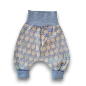 Hellblaue Babyhose mit elastischen Bündchen an Bauch und Beinen sowie weichem Stoff und lockerer Passform. Der Stoff ist mit großen, weißen Punkten und einem dezenten Pastellmuster bedruckt. Zwei blaue Knöpfe und ein kleines Etikett befinden sich vorne rechts am Bund. Die Hose liegt flach vor weißem Hintergrund und ist komplett sichtbar