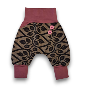 Gemusterte Babyhose mit weitem Schnitt, rosa Bündchen und zwei rosa Knöpfen für optimalen Sitz bei Stoffwindel- und Tragekindern.
