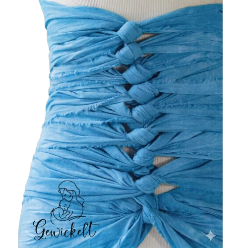 Nahaufnahme eines blauen Bengkung Belly Bind aus Baumwolle mit traditioneller Knotentechnik an einer Schneiderpuppe, Farbe Traum-Blau.
