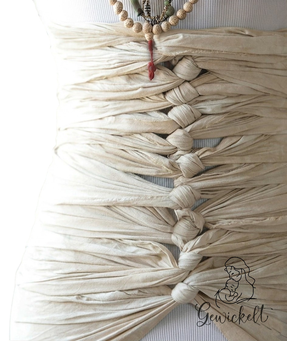 Nahaufnahme Bengkung Belly Bind an einer Büste gebunden. Vorne mit regelmässigen Knoten ineinander verschlungen