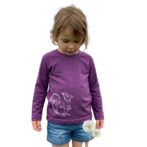 Ein Kind trägt ein lilafarbenes Kinder-Langarmshirt aus Merino-Seide mit Eichhörnchen-Print von heywool